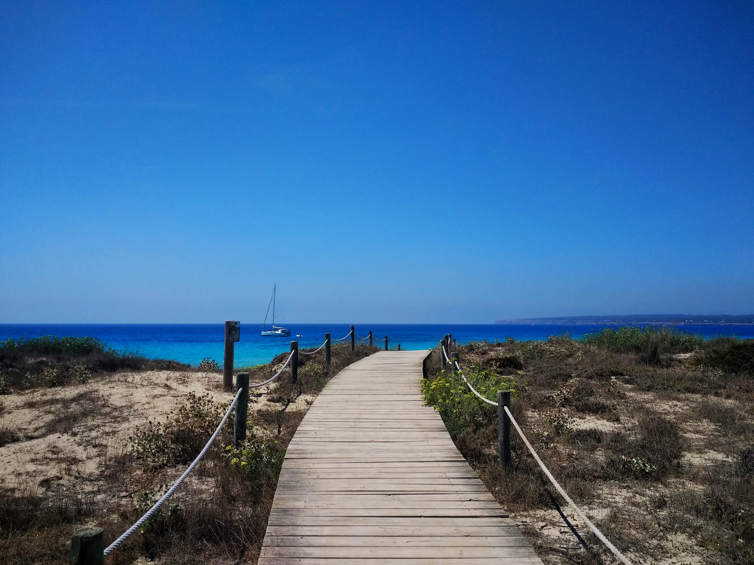 Beautiful shot of the boardwalk next to a beach in Formentera, Spain